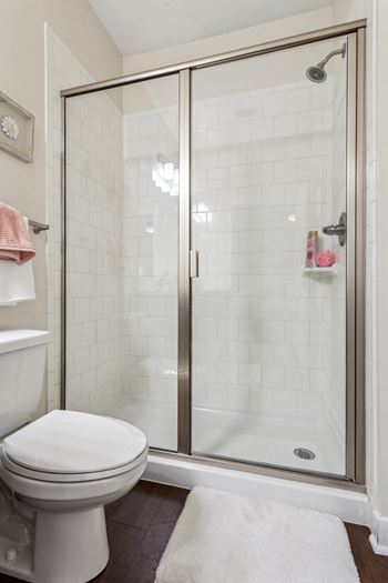 A white toilet sits next to a walk-in shower.at Century Hampton Roads, Suffolk, 23435  